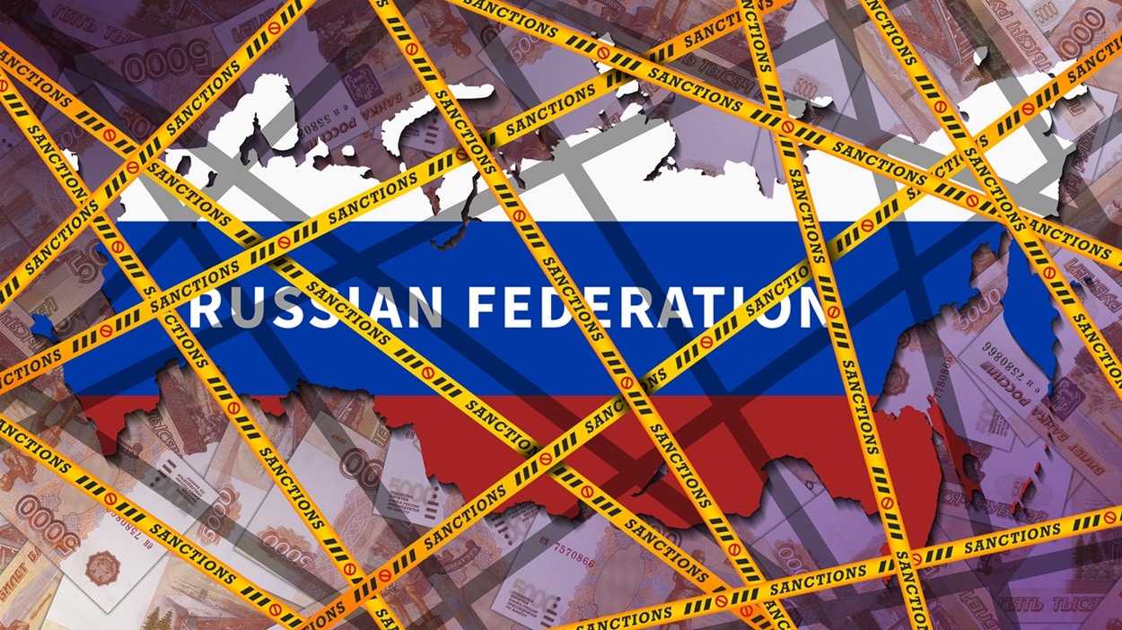 Yellow tape emblazoned with the inscription “sanctions” around a map of the Russian Federation, decorated in the colors of the same country’s flag.